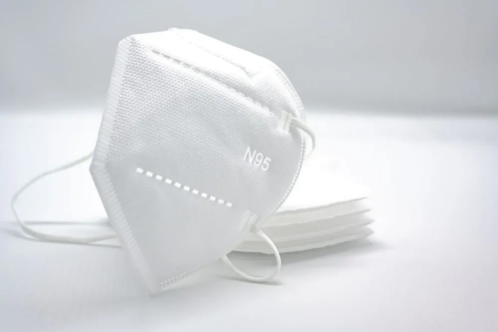 Stack of white N95 masks on a white background